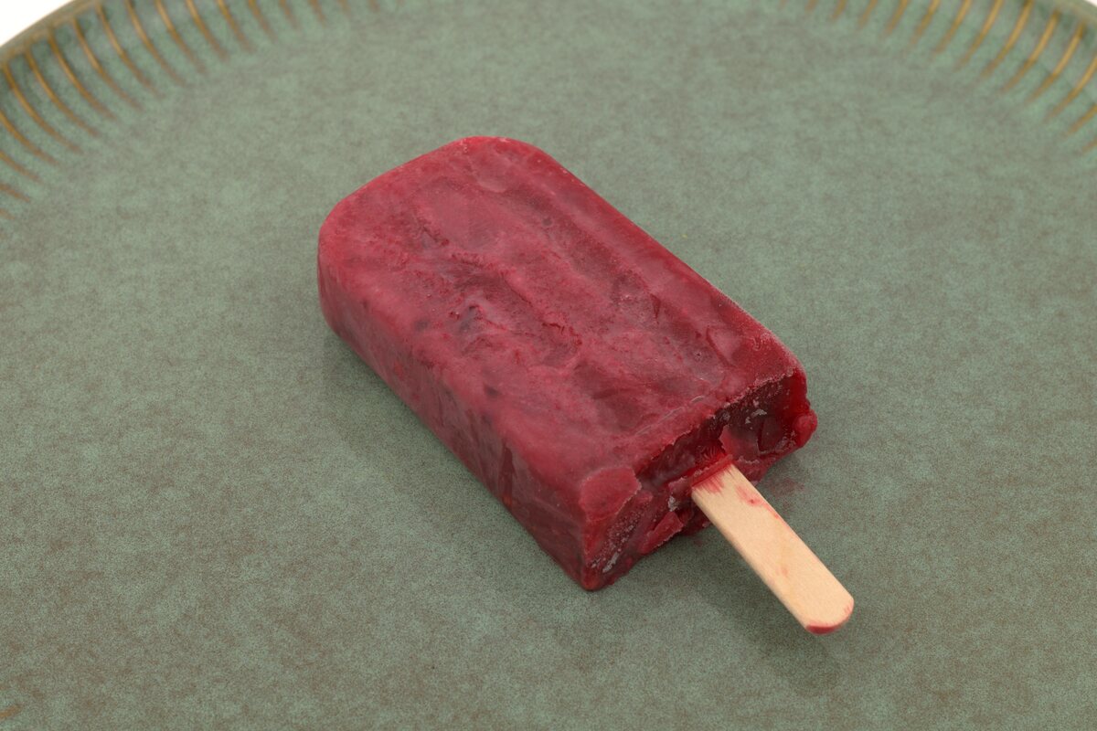Red Bastani Lavashaki mixed-berry ice lolly on a green ceramic plate